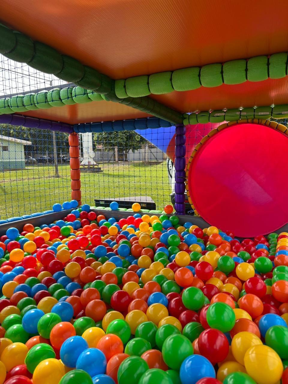 Piscina de bolinhas e passagem circular vermelha da Carreta Playground Land Toys durante o dia